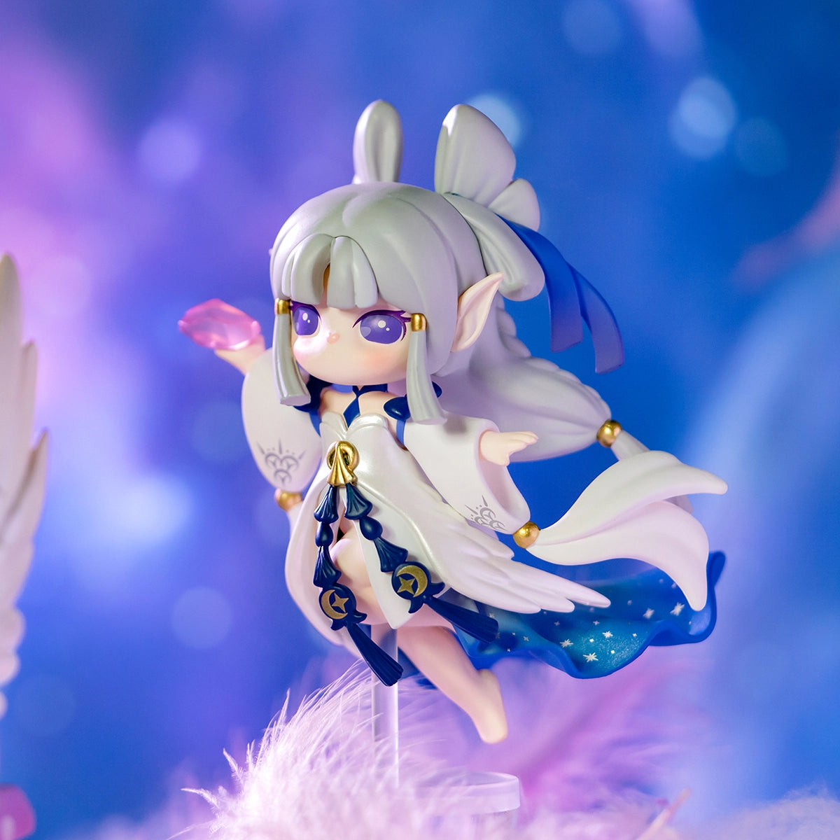 Chibi-style elf figurine from Paradise Guardians Blind Box Series, showcasing silvery hair, violet eyes, and starry gown, holding a pink crystal.