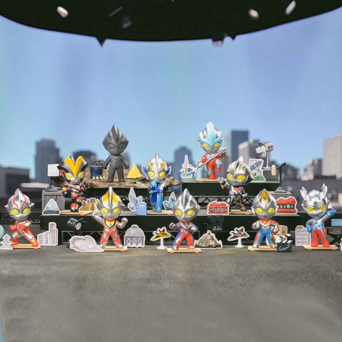 Ultraman Shooting Studio Series Figures displayed in a mini diorama with tiered platforms, featuring chibi-style heroes, urban props, and a UFO above.