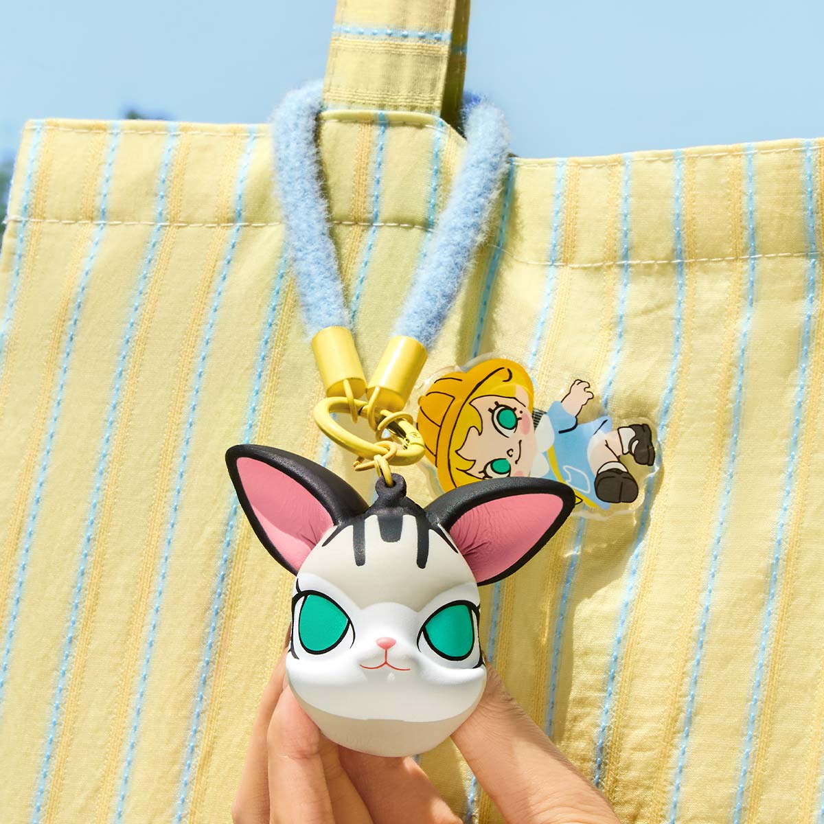 Hand holding a Baby Molly & Baby Tabby Series-Pinch Pendant Blind Box keychain featuring a cartoon cat face, made of PU Foam, hardware, and acrylic.