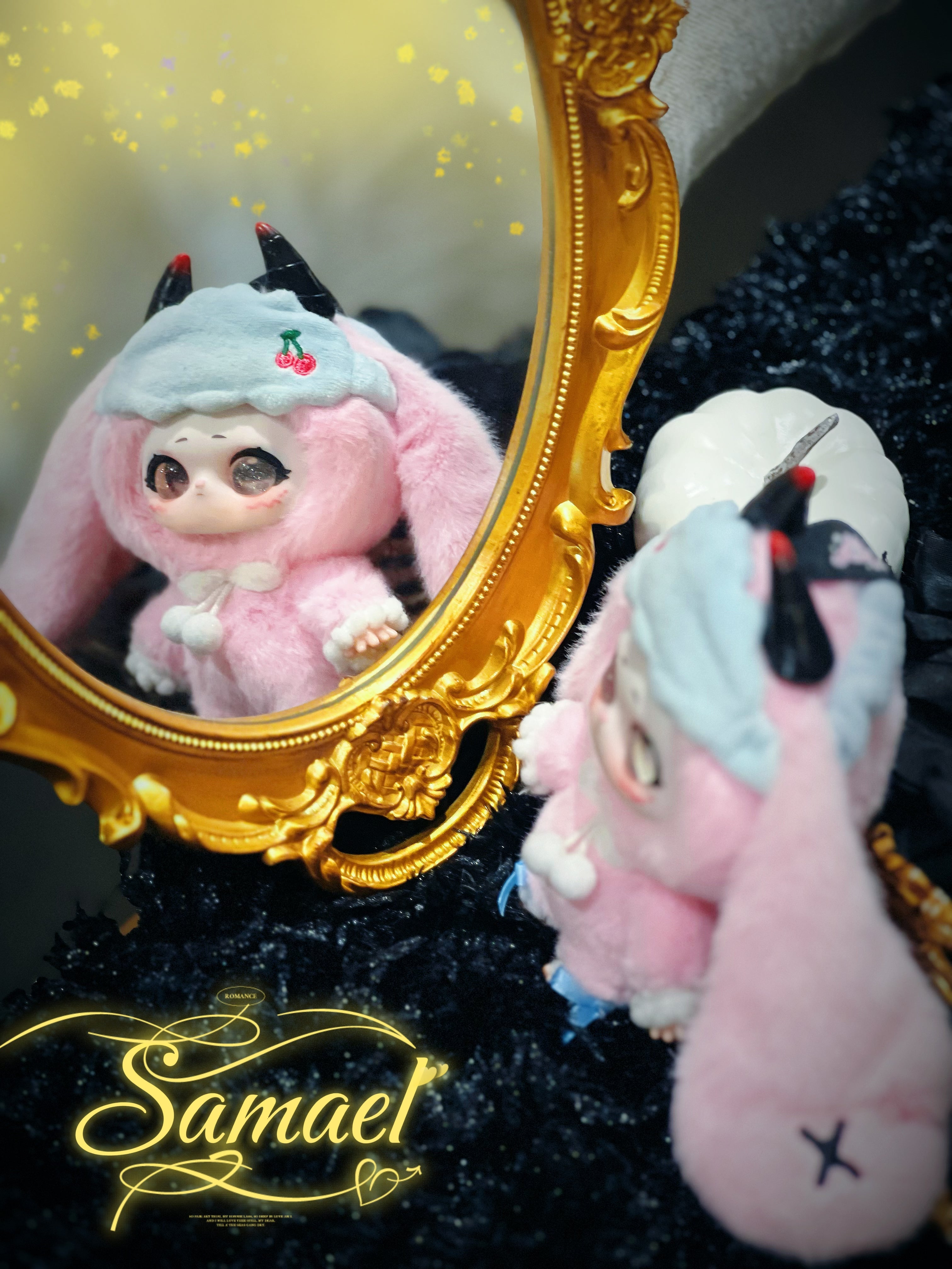 Baby Three - Shamali Magic Wardrobe toy with floppy ears and horns, reflected in a gold mirror, beside a decorative pumpkin. Preorder available at Strangecat Toys.
