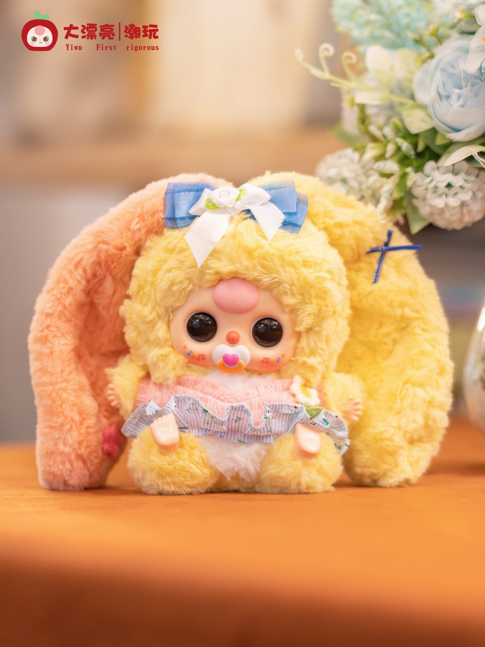 Baby Three - Lily Rabbit Town 4 plush toy in a bunny costume with a pacifier, oversized eyes, and a ruffled skirt. Preorder for October 2025.