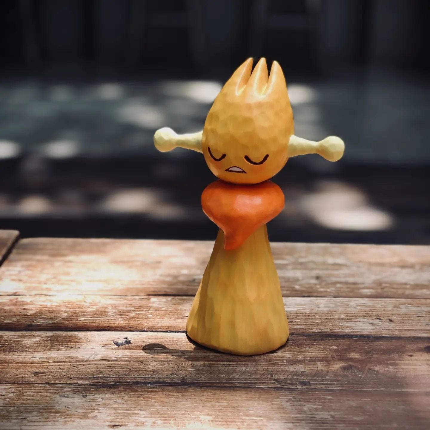 Resin figurine of Lucky Seijin - Jonas by JD Wang, a wooden toy cartoon character on a table.