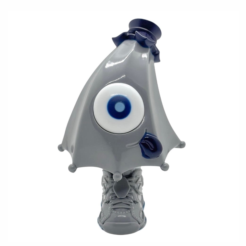 Kick Specter - grey by MARK's: A 12.5cm vinyl figure with a single eye, triangular hood, and sneaker base, embodying a ghostly, monster-like design.