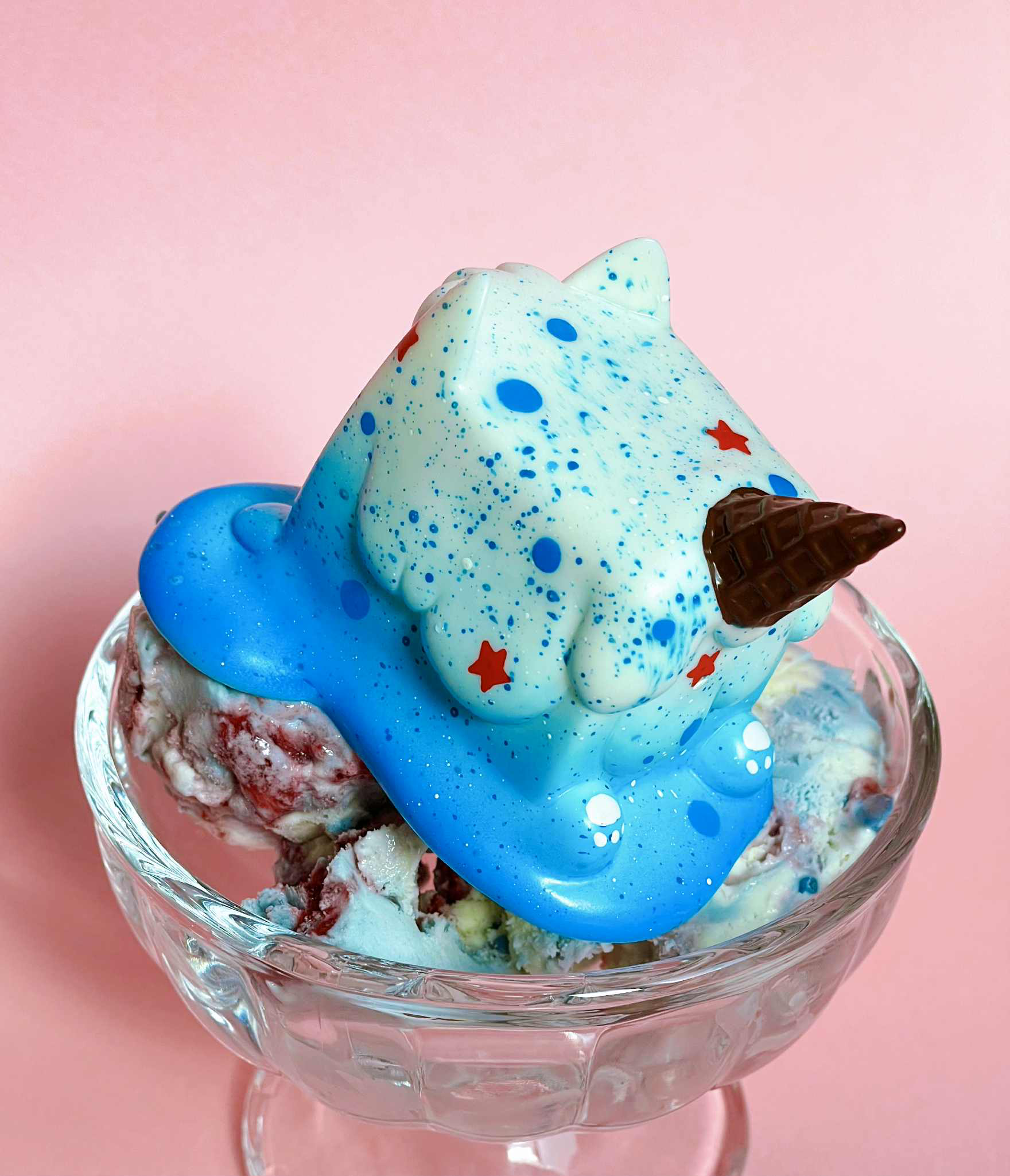 Popping Candy Ice Cream Cat by Rato Kim - Preorder; a cat-shaped toy with waffle cone horn atop fruit-swirl ice cream in a glass dish.