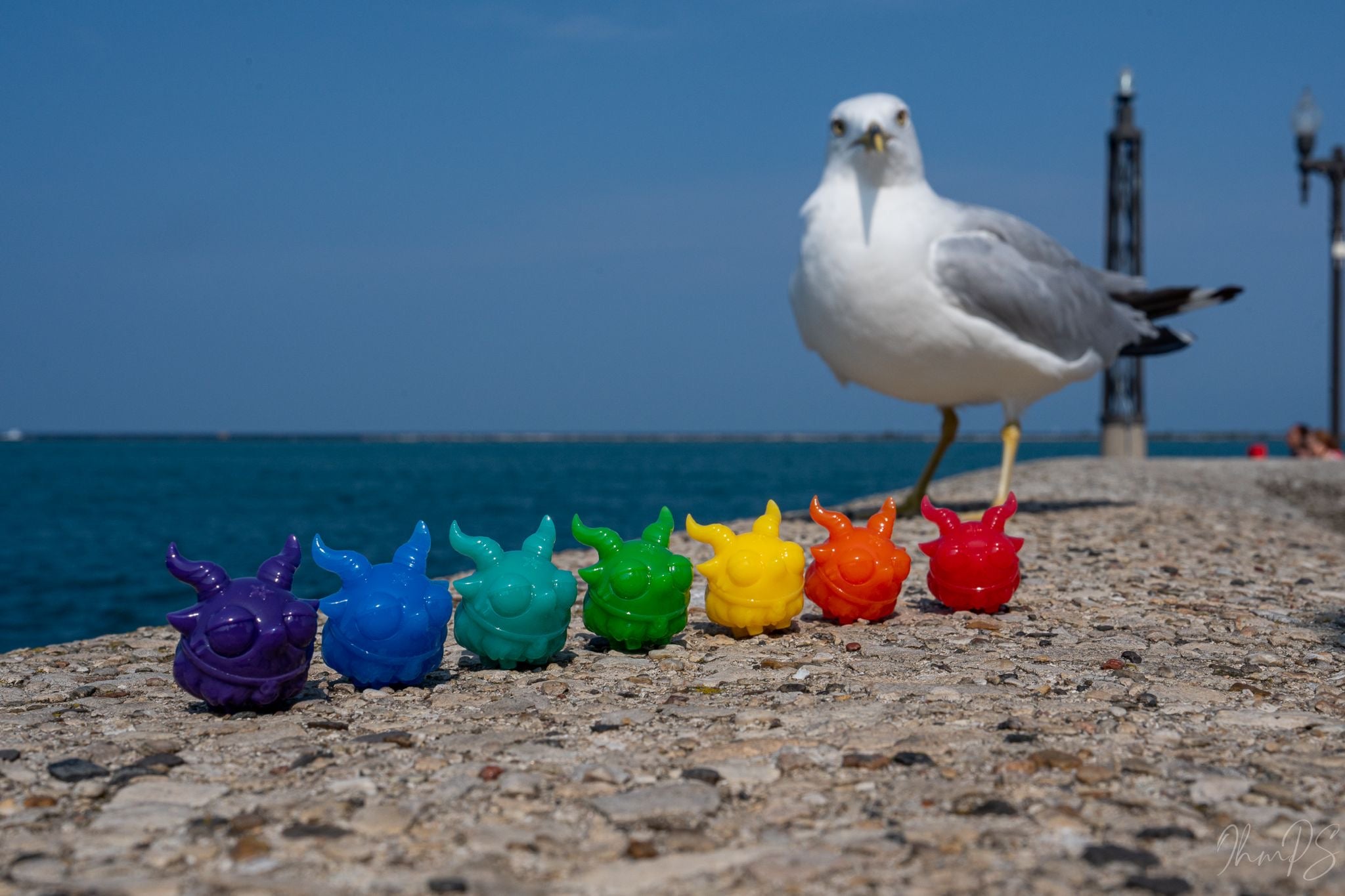 Rainbow Micro Bobbi Set by Zintears, featuring colorful resin toys with horns, limited edition of 100 sets, displayed with a seagull in the background.