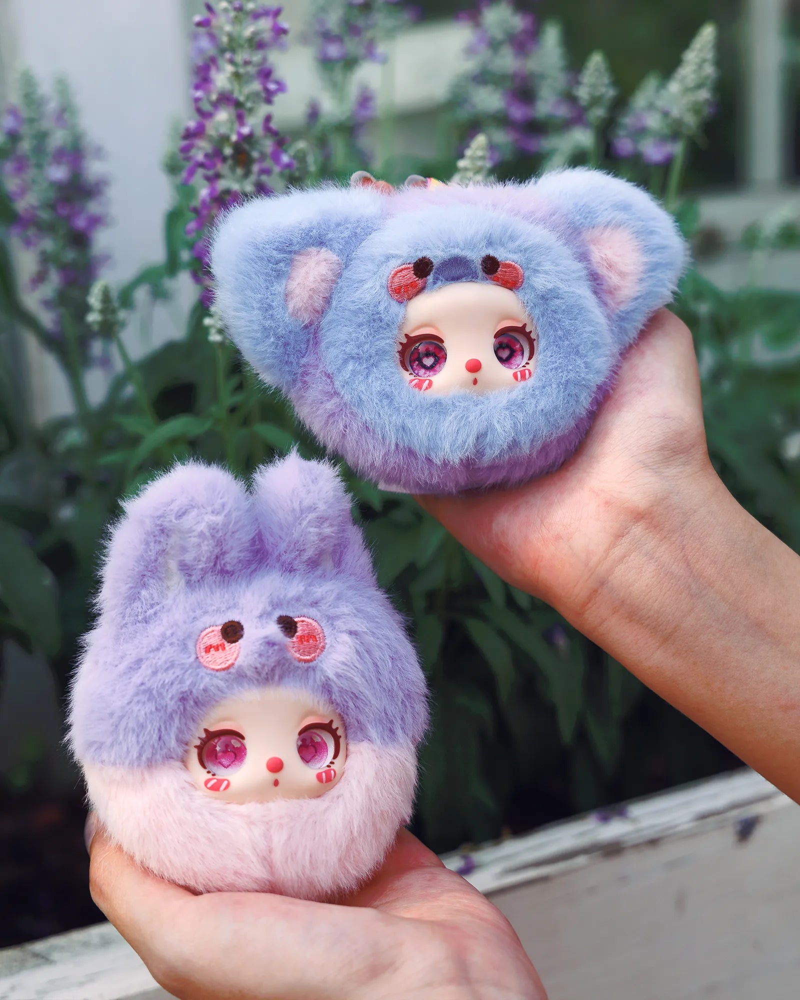 Liila’s Garden Tea Party Mini Plush Blind Box features two animal-eared plush dolls with pastel fur and vinyl faces, held amidst a floral backdrop.