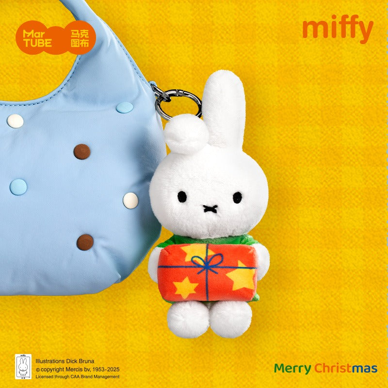 Miffy Winter Plus Keychain Blind Box featuring Miffy with a gift, attached to a bag, promoting holiday spirit. Preorder available at Strangecat Toys.