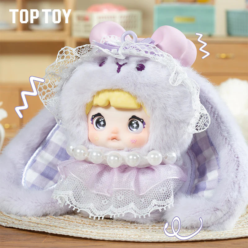 Nommi Baby Sweetheart Bunny Plush Blind Box features a kawaii doll with big eyes, fluffy lavender bunny-ear hood, lace ruffles, and faux pearls.