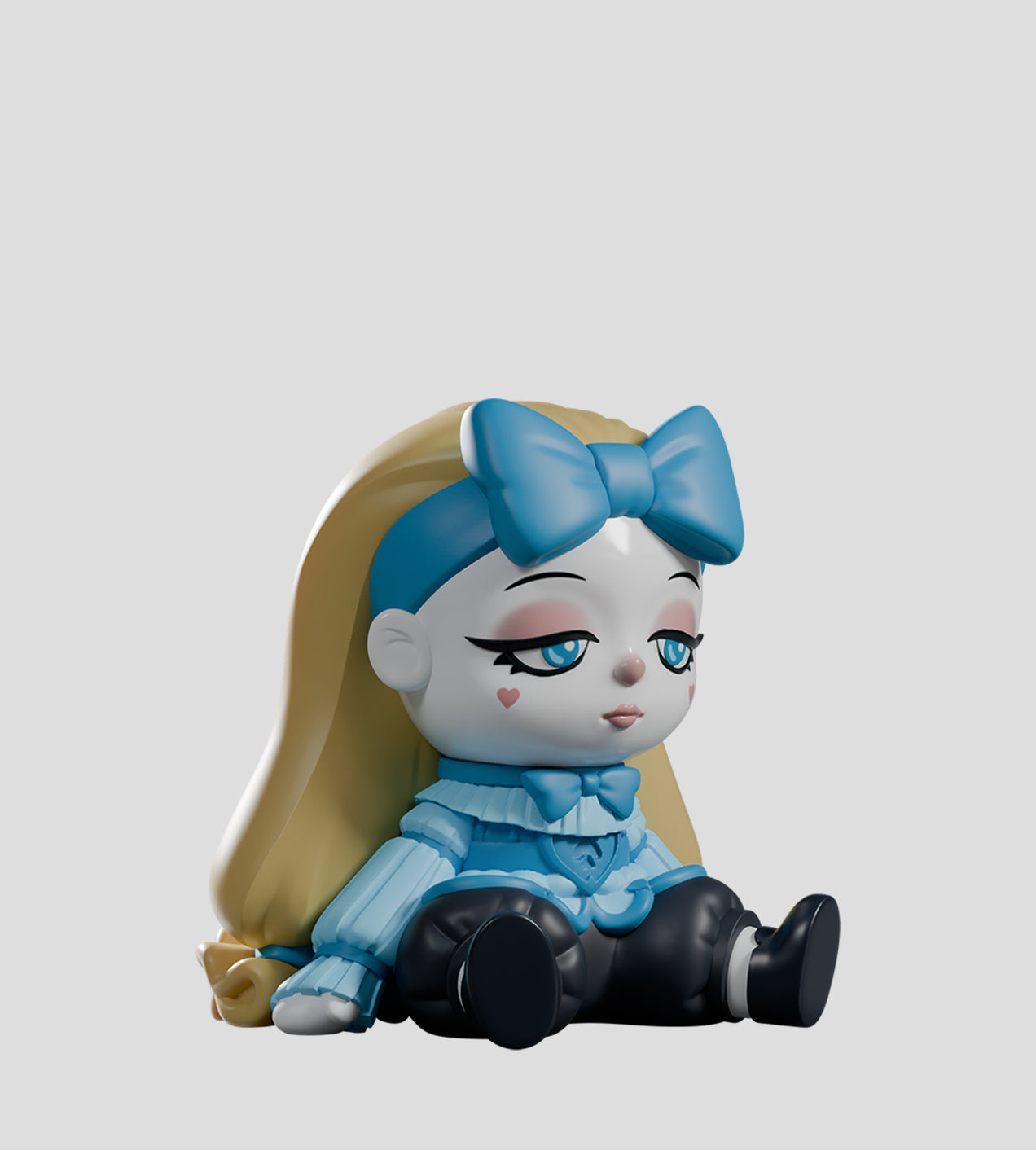 A Mad Tea Party Blind Box toy: a vinyl figure of a girl-like character with blonde hair, blue bow, and heart-marked cheeks, dressed in pastel-blue.