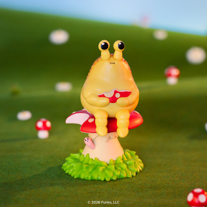 Blonks Animal Afternoon Premium Blind Box by Sad Salesman: A yellow creature on a toadstool, holding a mushroom slice, with a whimsical, grassy backdrop.