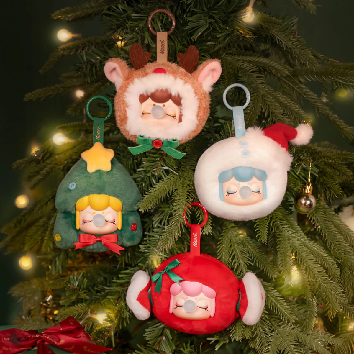 Rolife Nanci's Christmas Gift Plush Pendant PZC13: Four holiday-themed key-chain ornaments on a pine branch, featuring reindeer, Santa, earmuff, and Christmas tree designs.