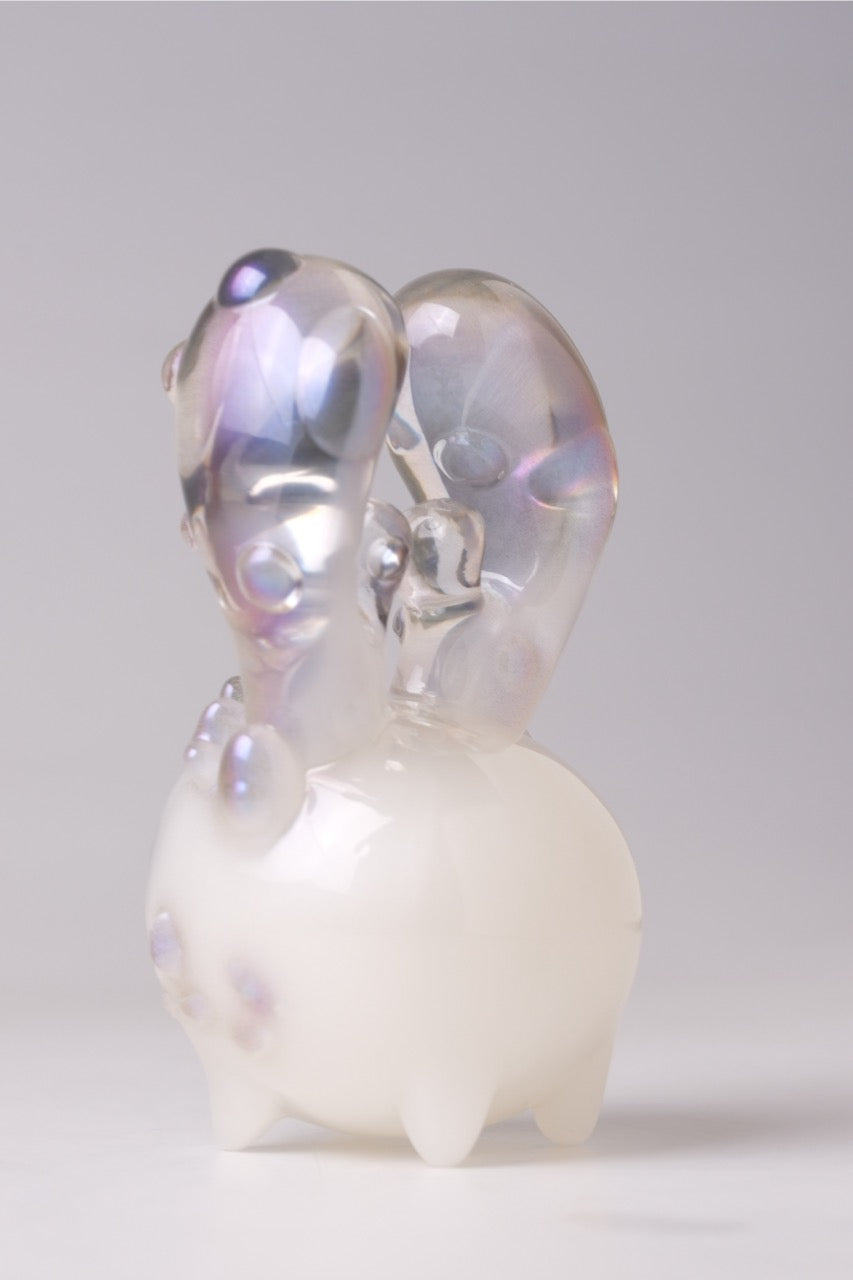 Coralite by Yutoos, a 4-inch limited edition resin sculpture, features a spherical base with iridescent, looping appendages, offering an ethereal, bioluminescent aesthetic.