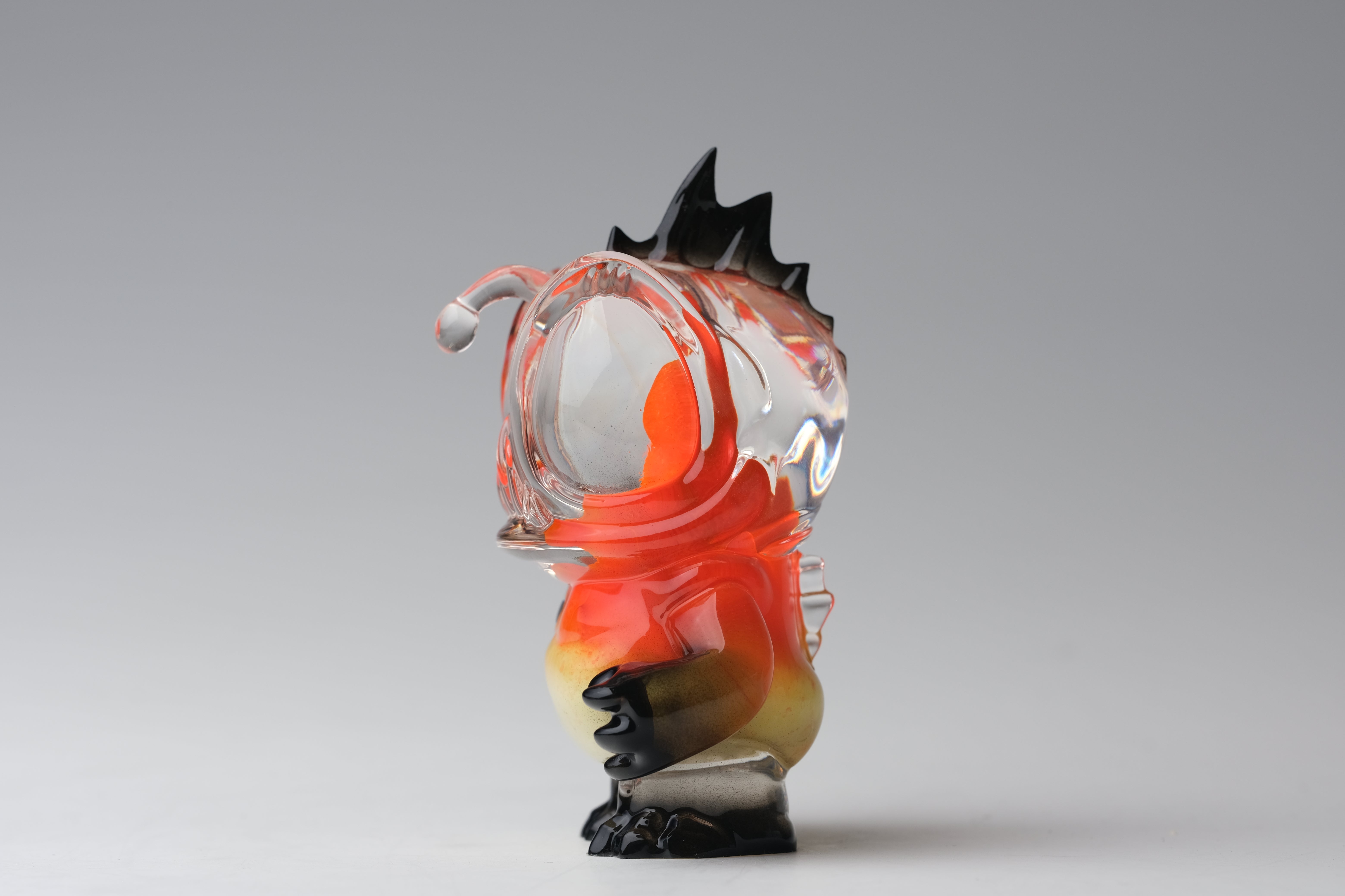 Angie Evo - Chicago Fire by 5th Turtle: A 3.5 hand-blown glass sculpture depicting a whimsical fish-seahorse creature with orange and yellow swirls, limited to 50 pieces.