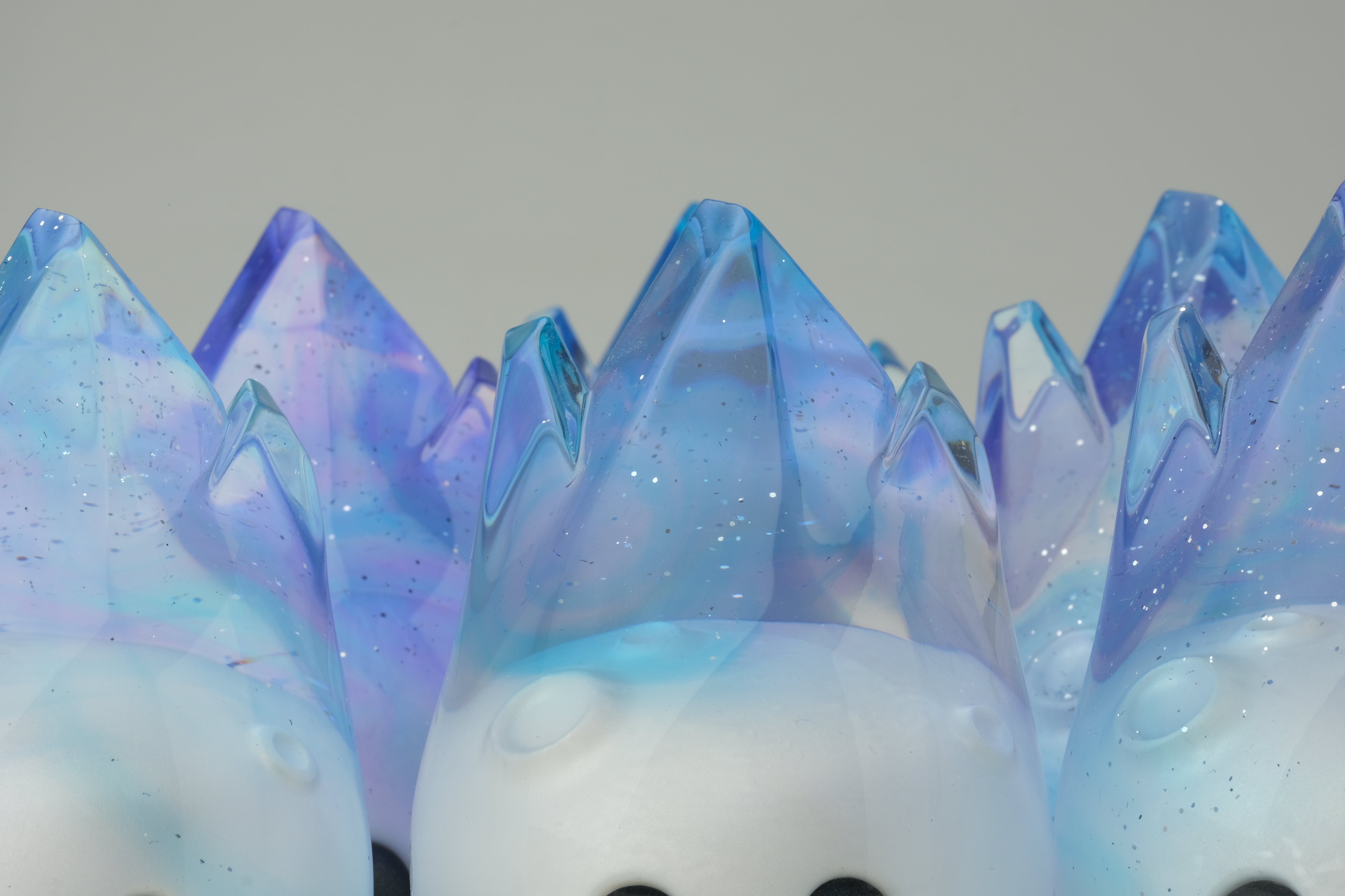 Aurora Cosmite by Yutoos: A 3.5 resin figurine with matte-white body, black eyes, and iridescent blue-purple crystal peaks, unique edition of 50.