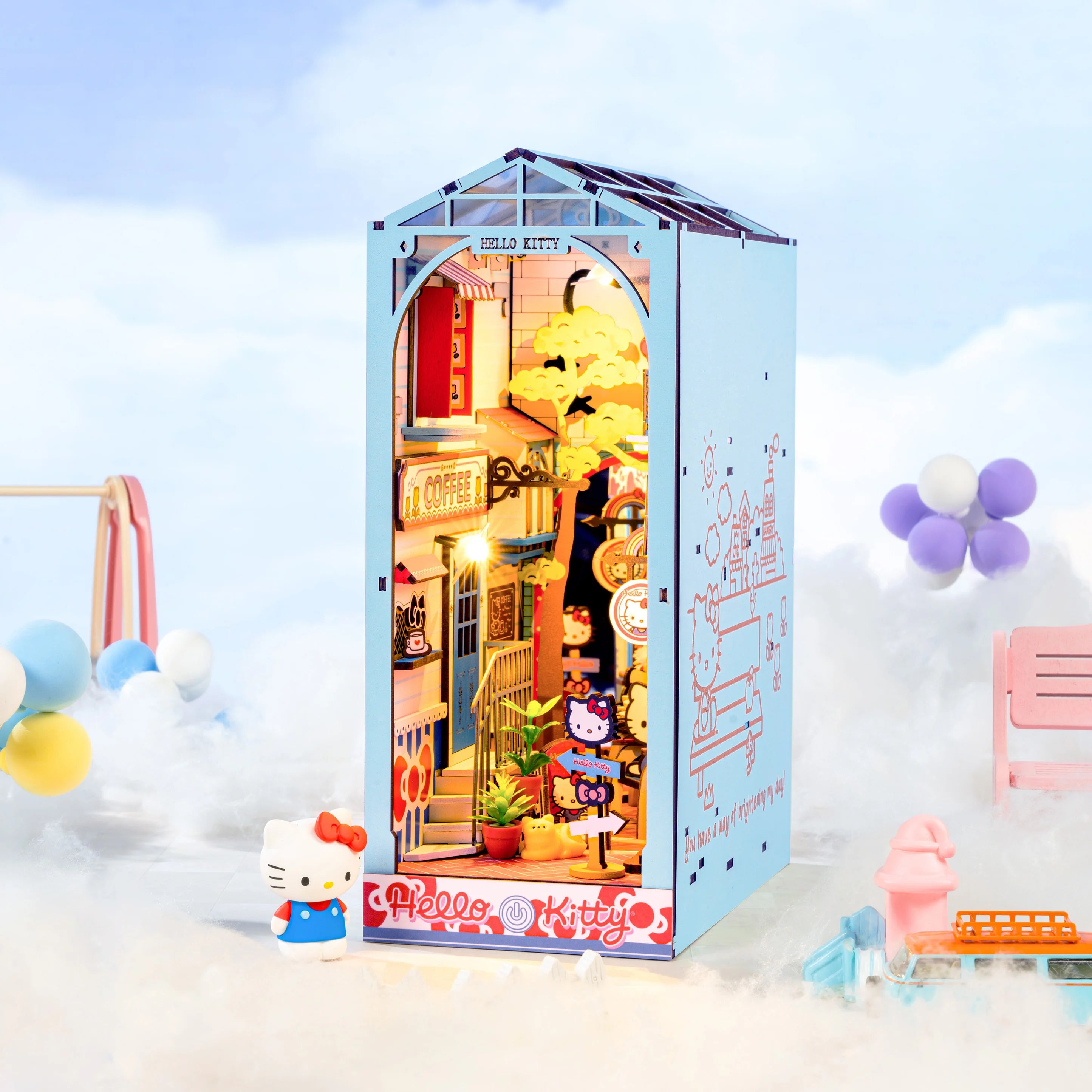 Hello Kitty® Town Square Booknook features a cozy diorama with cafes, plants, and Hello Kitty figurine, illuminated by touch-activated LED lights.