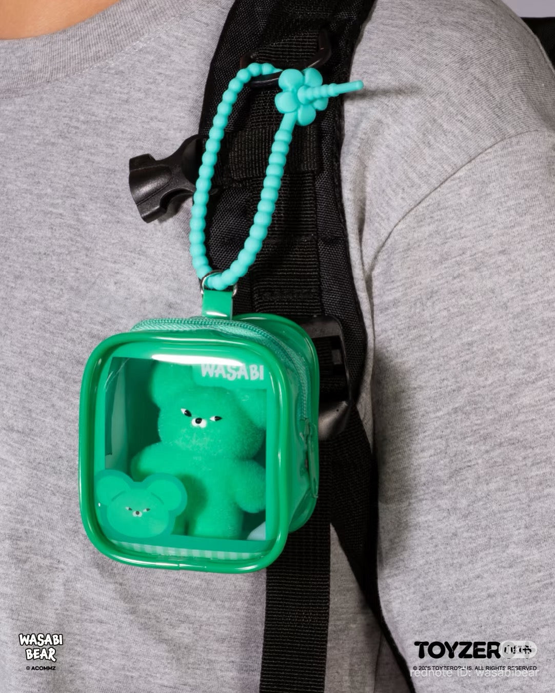 Wasabi Bear Outing Pals Series Blind Box features a green bear figurine in a translucent pouch, clipped to a backpack strap with a beaded loop.