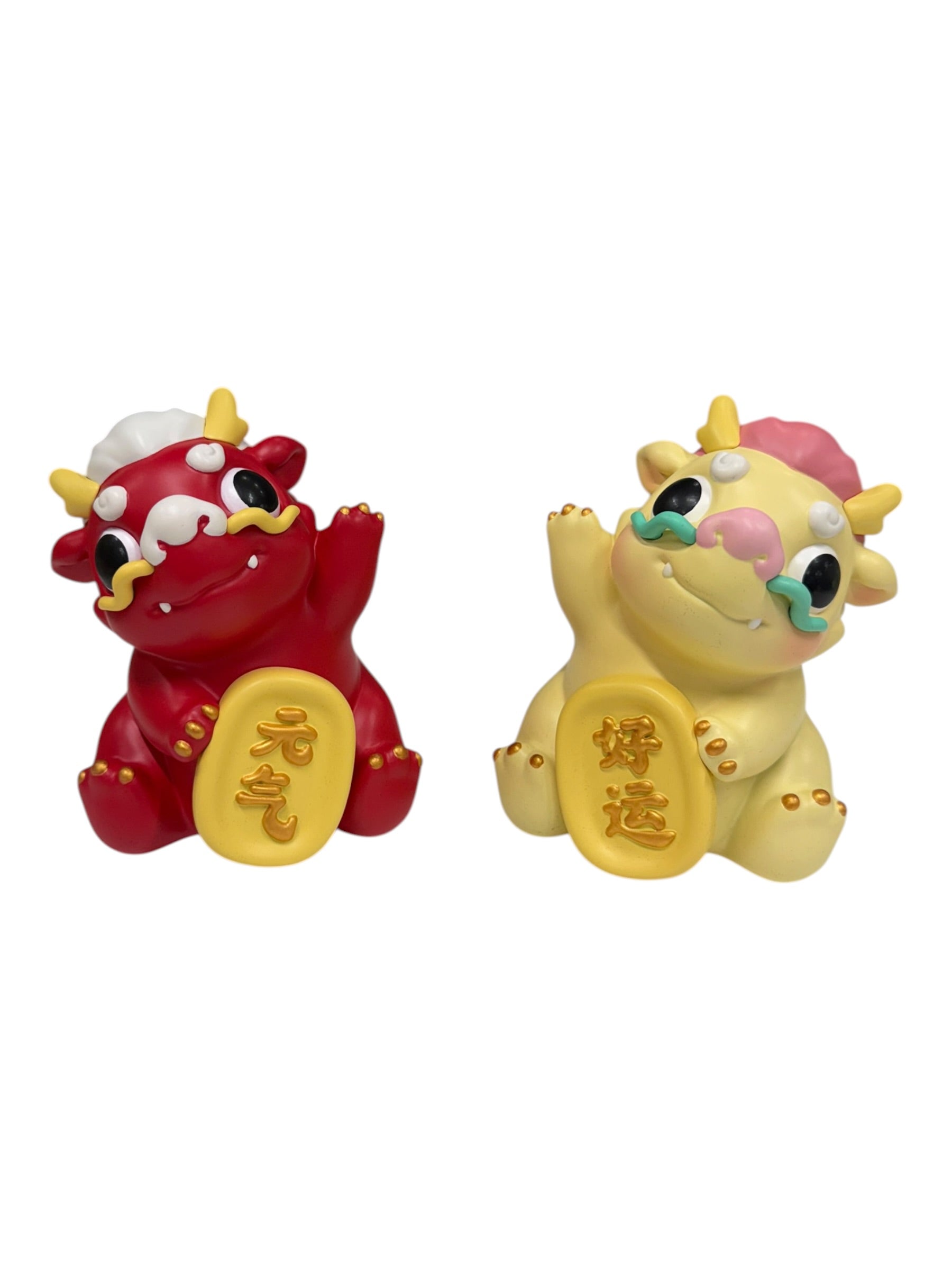 Kemelife Long features two resin figurines, stylized as cartoon oxen, each holding a gold plaque with Chinese characters for vitality and good luck.