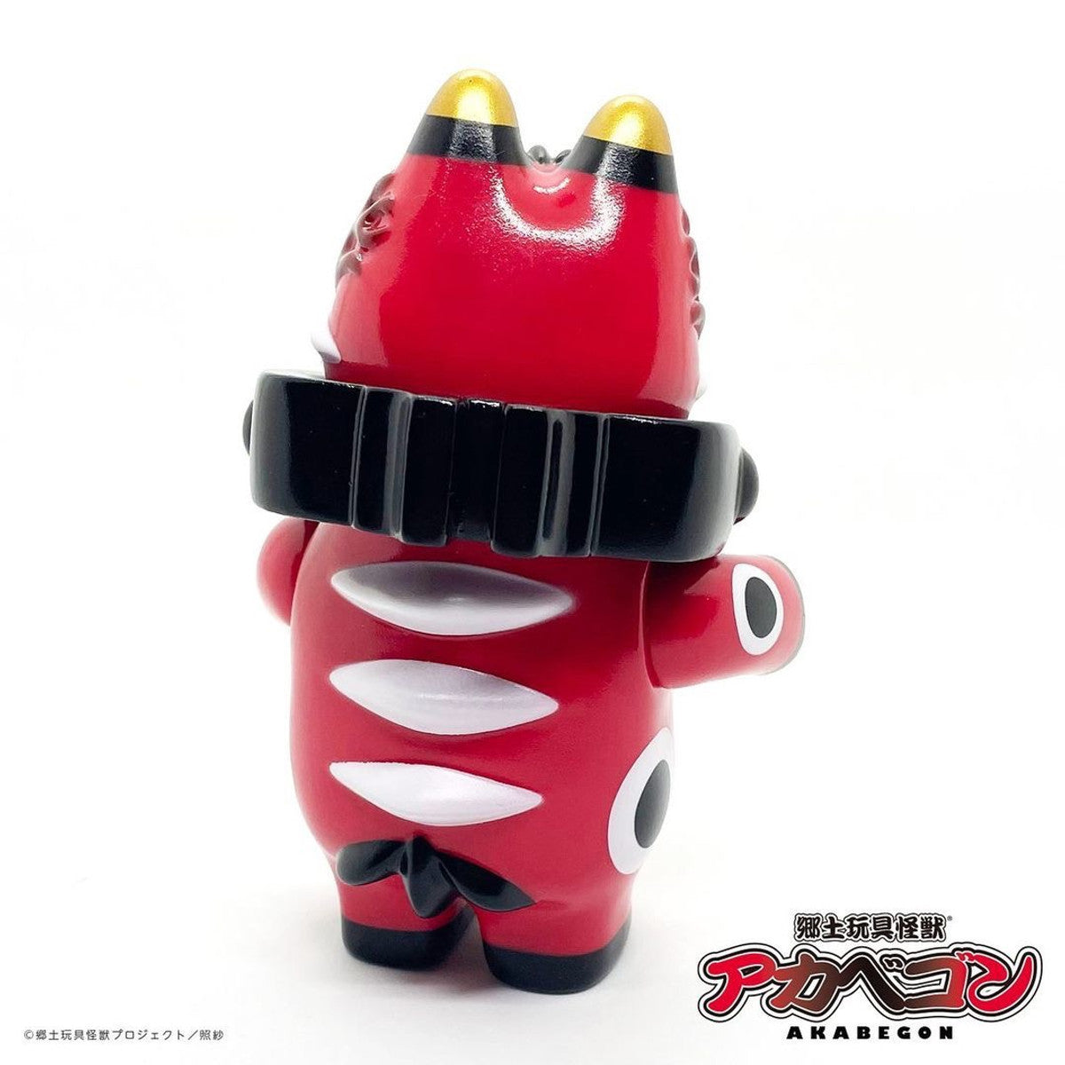 AKABEGON - Red by Teresa Chiba: A 12cm red vinyl toy ox with gold-tipped ears, white patterns, and a black collar, featuring big side eyes.