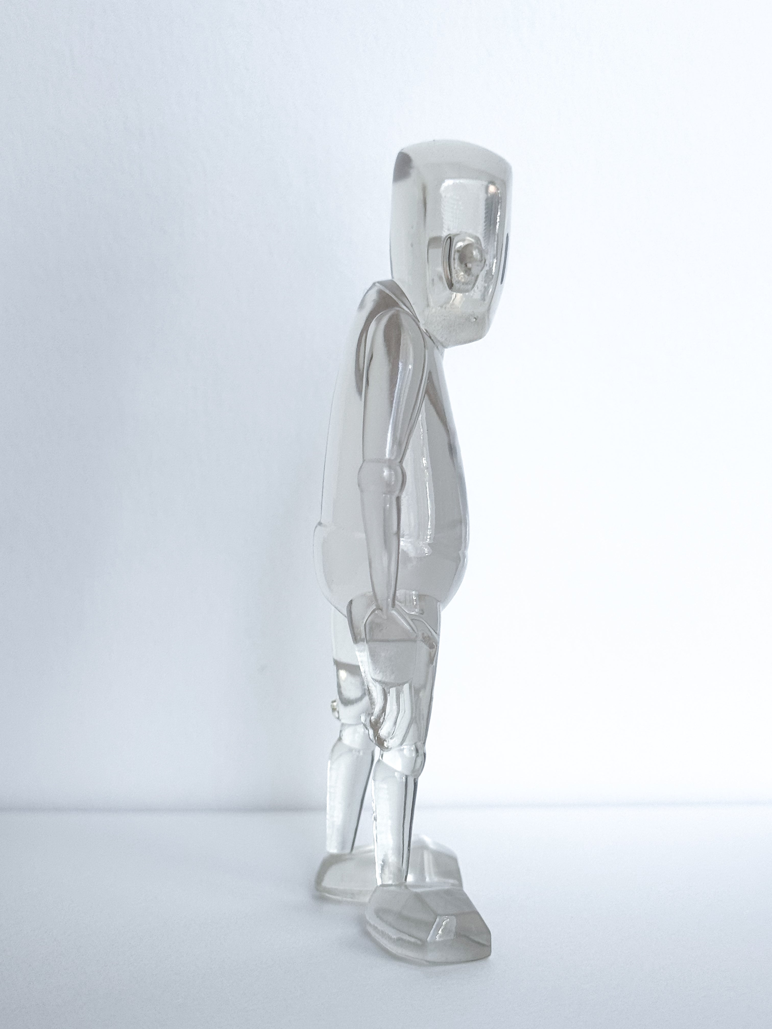 Clear acrylic figure, Time Will Tell - Thinking Clearly by Chris RWK, 3.5 tall, poseable with blocky limbs and joints, resembling an artist's mannequin.