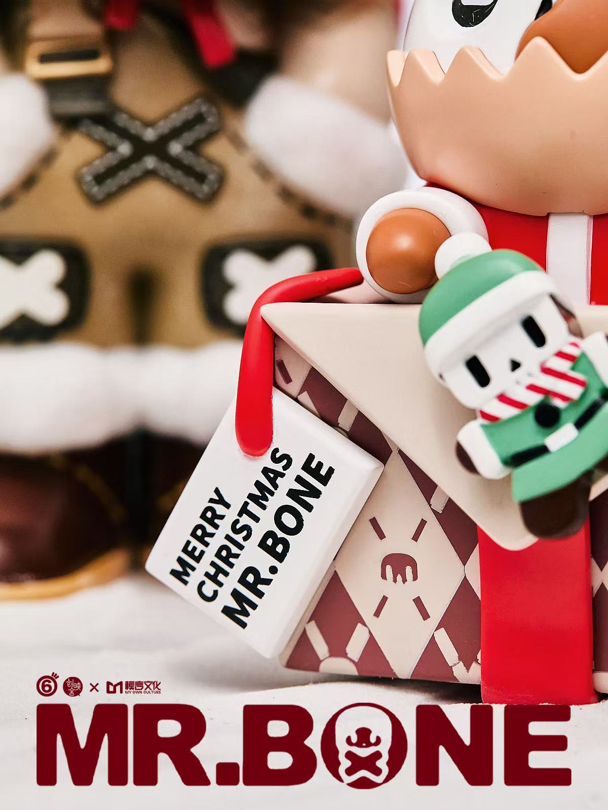Mr. Bone (200%) - Christmas Limited Edition - Preorder: A festive skeleton toy in holiday attire, perched on a gift box with a Merry Christmas tag. Limited to 300 worldwide.