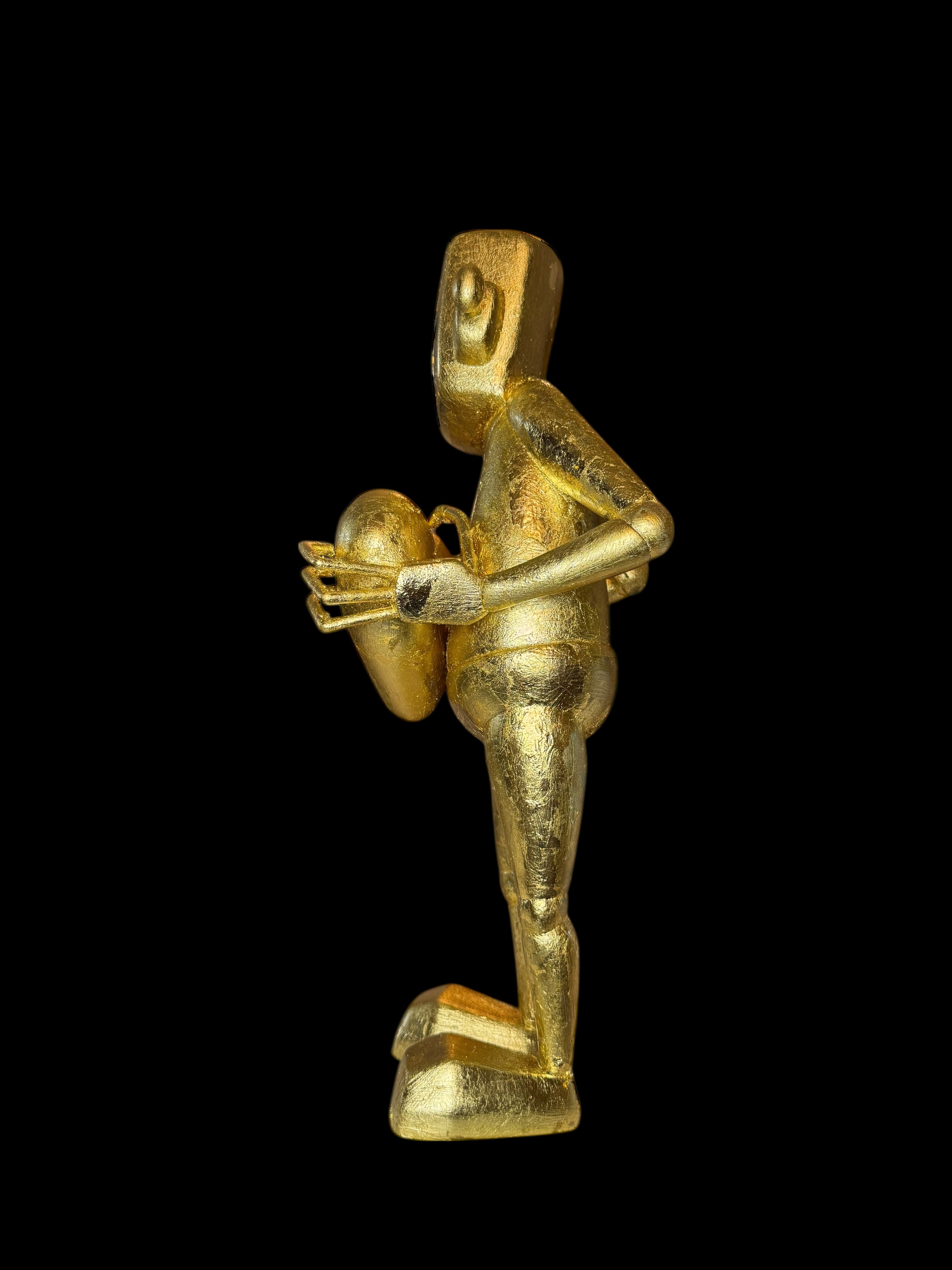 Time Will Tell - 'False idle' by Chris RWK: A 15-inch, all-golden, abstract humanoid statuette holding a small round object, crafted with gold leaf.