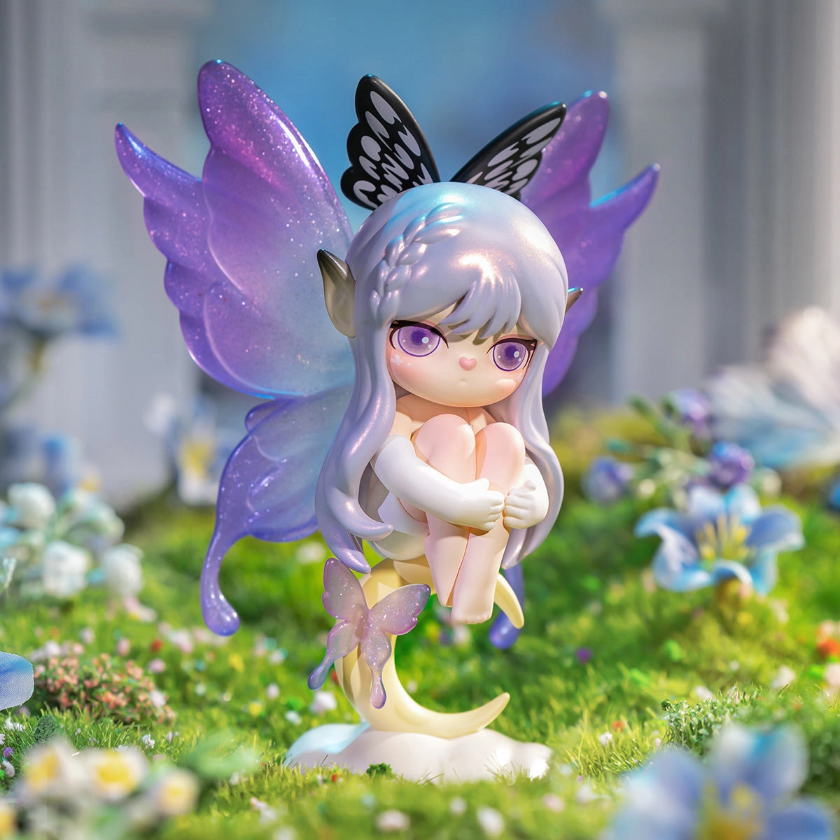 Suri's Mystery Castle Blind Box Series features a whimsical fairy figure on a crescent moon, surrounded by a vibrant, miniature flower meadow.