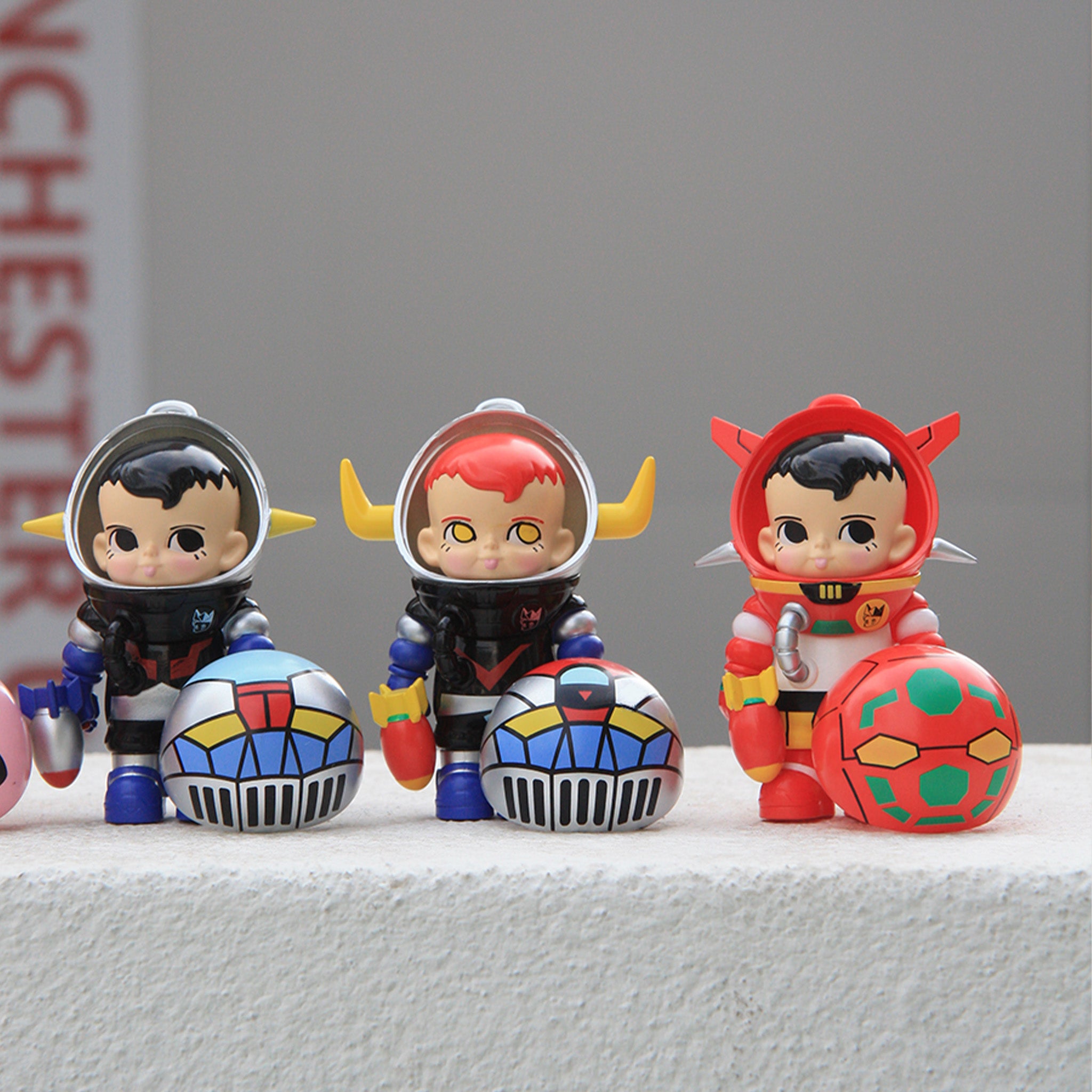 SAMSAM ADVENTURER X GO NAGAI BLIND BOX features three stylized vinyl figures with removable robot-face helmets in unique suits, showcasing collectible designer toys from Strangecat Toys.