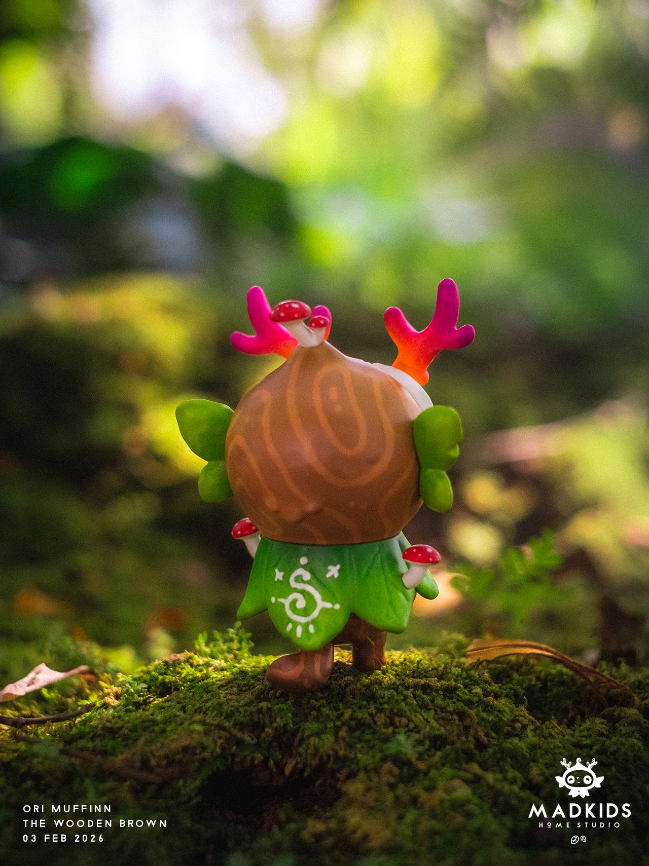 Ori Muffinn: The Wooden Brown art-toy with pink antlers, mushroom details, and a leaf-patterned cloak, displayed on forest moss, by MadKids, 9.5 cm tall.