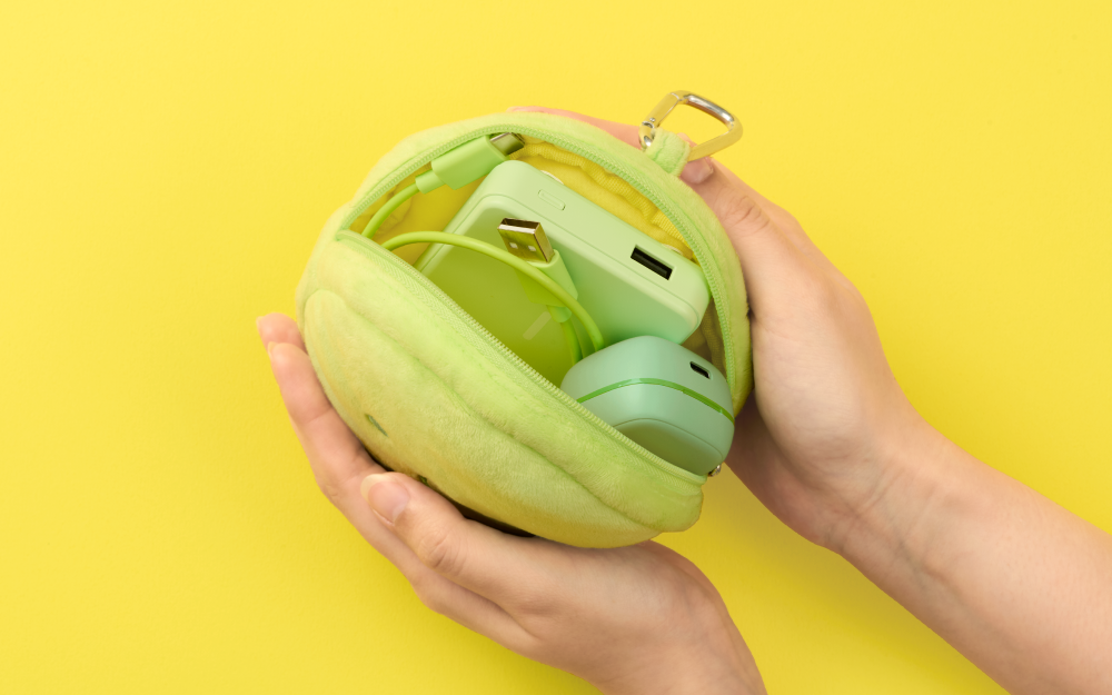 SMISKI Cushion Pouch - Preorder: Lime-green plush pouch with USB cable, power bank, gadget case, SMISKI Hugging Knees charm, ideal for small accessories.