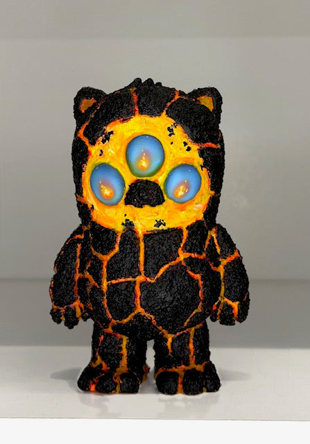 Beans Group Show - Caldera Cat, a 5-inch resin designer toy, features a bear-like figure with lava-like cracks and three glowing blue eyes. Preorder available.