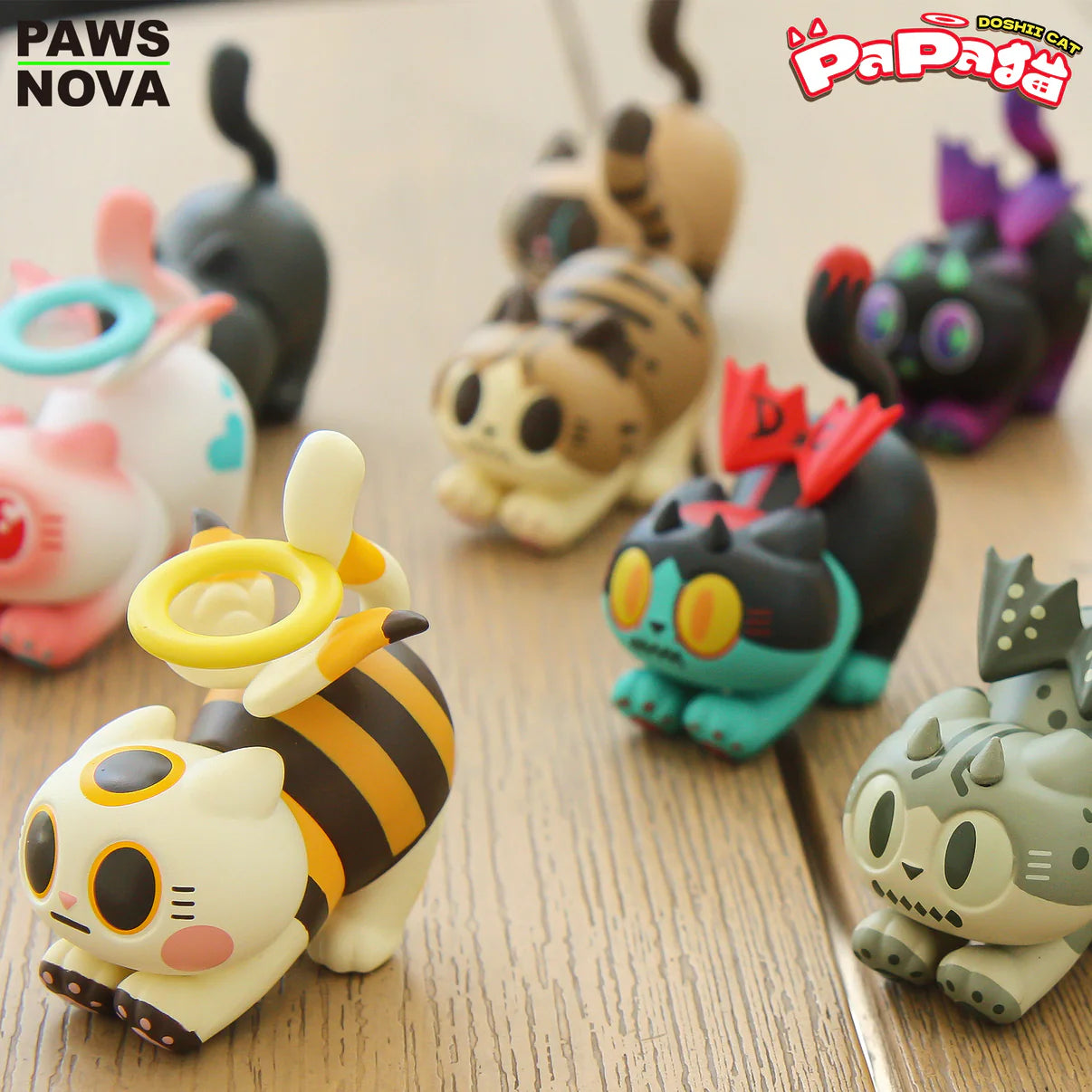 TROUBLE CREW PAPA CAT BLIND BOX features vinyl cats in unique poses and themes, including bee, bunny, and dragon, showcased on a wooden surface.