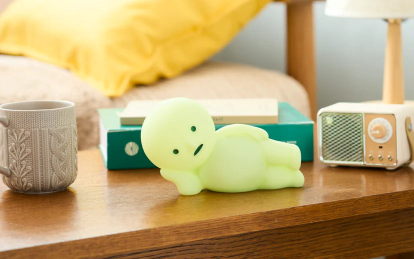 SMISKI Touch Light Vol. 2 reclining on a nightstand with a mug, books, and retro speaker; a unique art toy from Strangecat Toys.