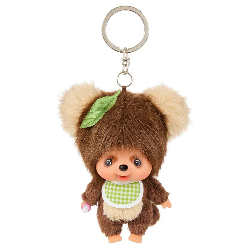 Monchhichi TanuTanu Keychain: Plush toy keychain featuring a fuzzy bear-like character with a green gingham bib and leaf, attached to a metal ring.