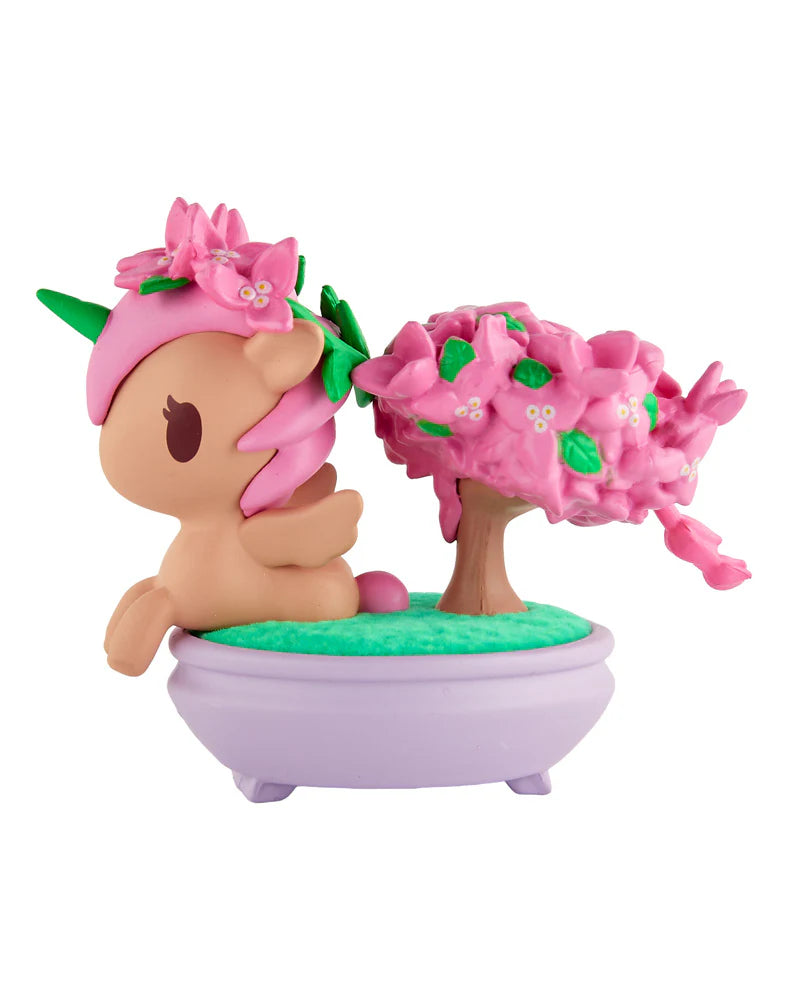 Botanical Bonsai Unicorno - Pink Bougainvillea features a tan unicorn with pink mane, green horn, in a lavender pot with a pink-blossom bonsai.
