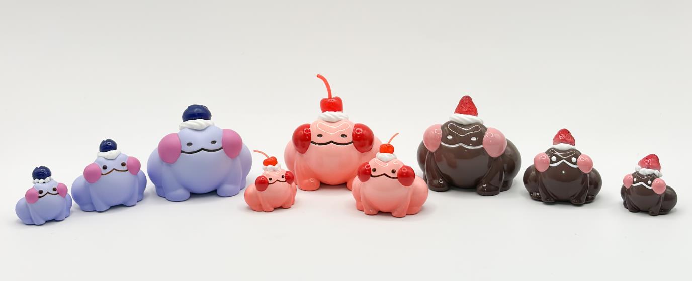 A blind box and art toy store alt text: Dudu with Dessert by Wish Land, a resin 3.5 toy animal figure wearing a hat, surrounded by small ceramic figurines and a chocolate dog figurine.