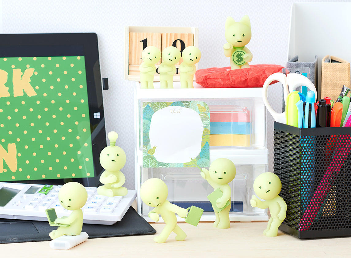 A group of small figurines and toys from the Smiski at Work Blind Box Series.